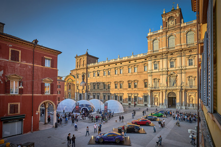 The Piazza Roma in Modena, with domes containing the racing sleds and a display of real cars included in Gran Turismo Sport. The building is the Palazzo Ducale.